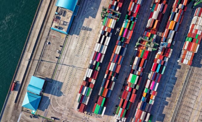 Top view of colorful shipping containers at a bustling port in Jakarta, Indonesia.