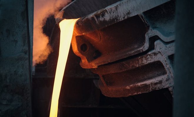 Molten metal pouring from ladle in industrial foundry, capturing the intense heat and energy.