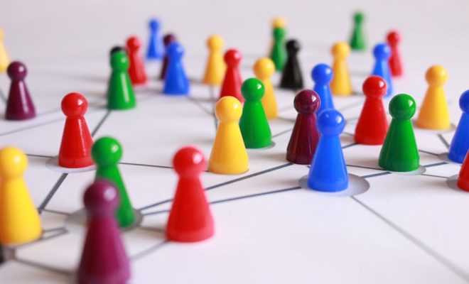 A strategic arrangement of colorful pawns connected on a game board, symbolizing networking and teamwork.